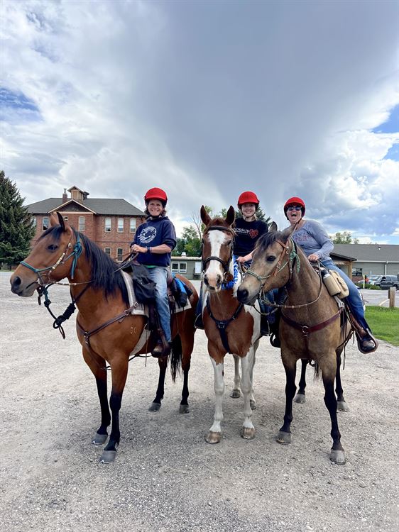 family on horses in front of school